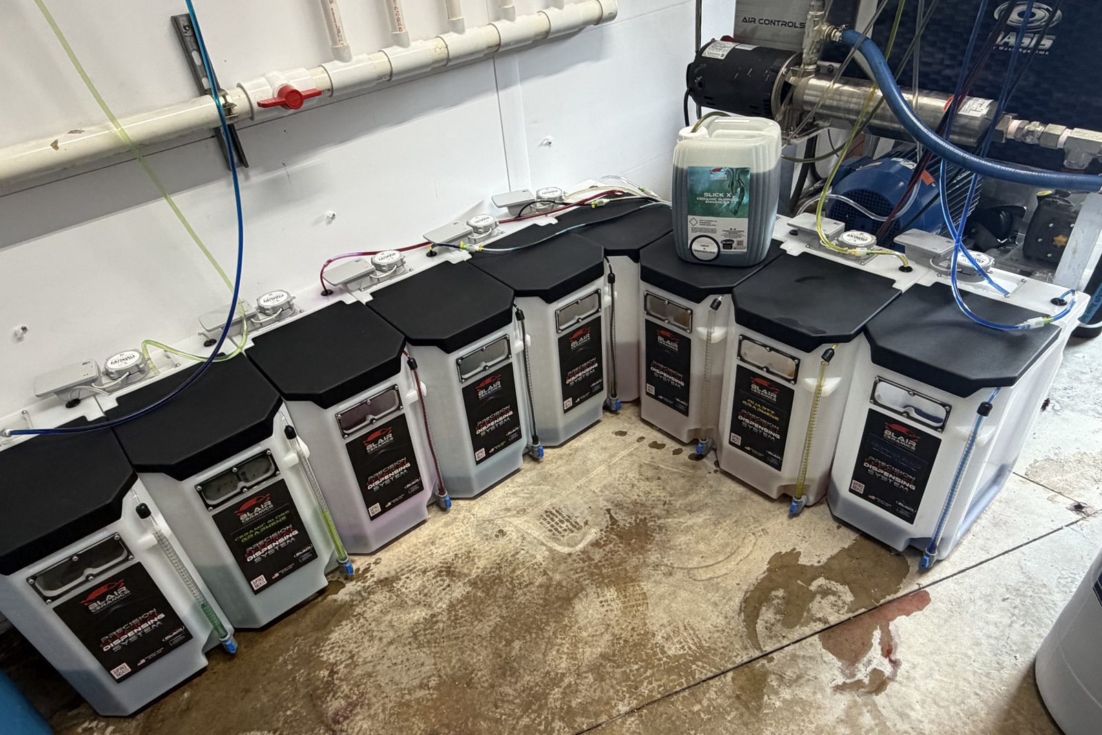 Chemical room after the install, with Blair Ceramics precision dispensing tanks lined up along the wall and feed lines labeled